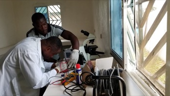 Peter Kaung repairs a microscope in his workshop